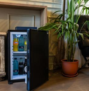 un réfrigérateur ouvert rempli de boissons et d'une plante en pot dans l'établissement El Avenida Palace, à Barcelone