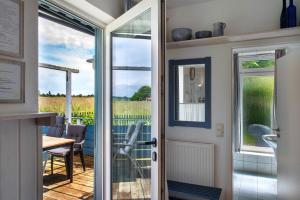 a door leading to a patio with a table and chairs at Möve Aba Bungalow 68 in Rerik
