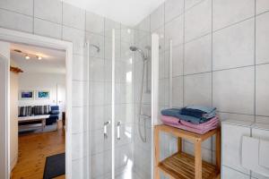 a bathroom with a shower with a glass door at Möve Aba Bungalow 68 in Rerik +14 photos