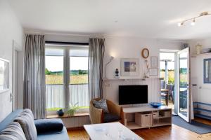 a living room with a couch and a tv at Möve Aba Bungalow 68 in Rerik