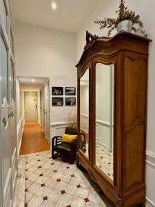 a room with a large wooden cabinet with a mirror at Les Suites du Cours & Spa in Aix-en-Provence