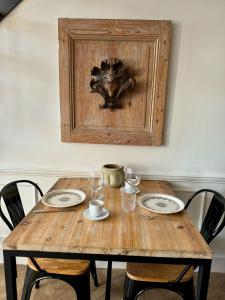 una mesa de madera con platos y vasos. en Les Suites du Cours & Spa en Aix-en-Provence