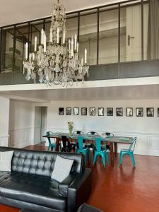 a dining room with a couch and a table and chairs at Les Suites du Cours & Spa in Aix-en-Provence