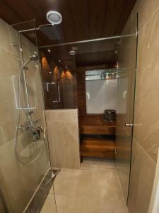 une douche avec une porte vitrée dans une salle de bain dans l'établissement Marina Resort C4, à Kalajoki 4 autres photos