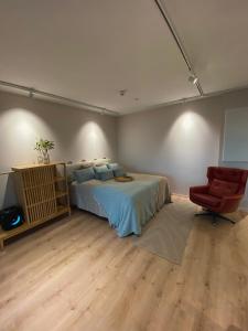 une chambre avec un lit et une chaise rouge dans l'établissement Marina Resort C4, à Kalajoki