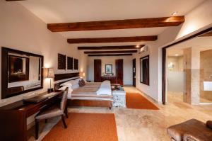 a bedroom with a bed and a desk and a television at Kapama River Lodge in Kapama Private Game Reserve