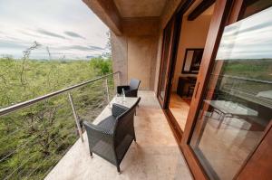 a balcony of a house with a table and chairs at Kapama River Lodge in Kapama Private Game Reserve