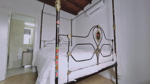 a bedroom with a white bed with a metal frame at STAY Akoni House in Droushia