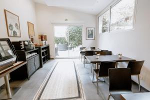une salle à manger avec des tables et des chaises ainsi qu'une fenêtre dans l'établissement Ideal Sejour Cannes - Stylish Boutique Hotel with quiet garden, à Cannes