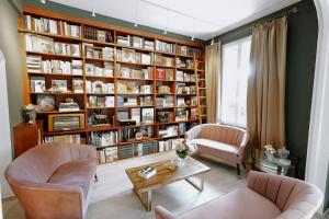 sala de estar con 2 sillas y estante para libros en Idéal Séjour - Boutique Hôtel Cosy, en Cannes