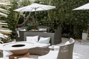 un patio con mesa, sillas y sombrilla en Idéal Séjour - Boutique Hôtel Cosy, en Cannes