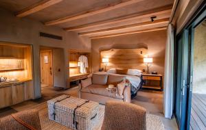 a bedroom with a bed and a couch and a chair at Kapama River Lodge in Kapama Private Game Reserve