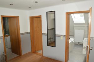 a bathroom with two doors and a mirror at 75qm Apartment in Burgstaedt