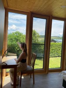 a woman sitting at a desk in front of a window at mein kleinDOMIZIL Mittenaar in Mittenaar +5 photos