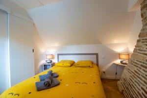 a yellow bed in a small room with two lamps at La Boutique 2 à 4 personnes in Lacave