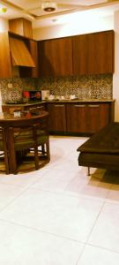 a kitchen with wooden cabinets and a table at Vaporium 2 bedroom Apartment in Rawalpindi