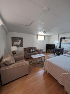 ein Schlafzimmer mit einem Bett, einem Sofa und einem Tisch in der Unterkunft La Maison Kelner in Saint Ludger de Milot