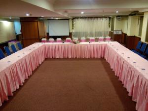 a long table in a room with pink tables and chairs at Hotel Sri Garden Sdn. Bhd. in Kangar