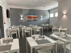 a dining room with white tables and white chairs at Boutique Hotel Nuovo Cason in Cavallino-Treporti