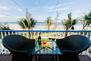 a table with a bowl of fruit on a balcony with the beach at Lee House Villa Tam Thanh in Tam Ky