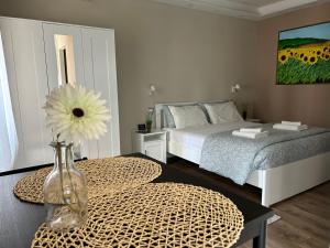 a bedroom with a bed and a vase with a flower on a table at La corte di Silvia CENTRO in Sesto Calende
