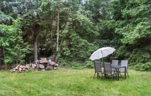 a table and chairs with an umbrella in the grass at 4 Bedroom Awesome Home In Frederiksværk in Frederiksværk +10 photos