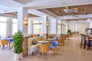 hol ze stołami i krzesłami oraz kawiarnią w obiekcie Universal Hotel Bikini w Cala Millor