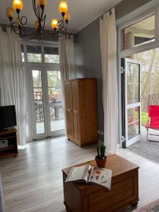 ein Wohnzimmer mit Couchtisch und Schiebetüren in der Unterkunft Apartament Pastelowy in Krynica Morska