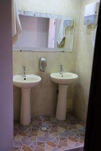 Usaquen Station Hostel في بوغوتا: حمام مغسلتين ومرآة
