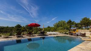 a swimming pool with a red umbrella and chairs at Kochab Sintra by LovelyStay in Sintra