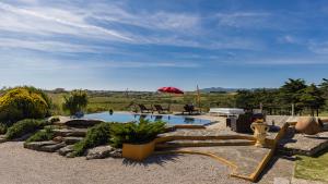 a swimming pool in a yard with a red umbrella at Kochab Sintra by LovelyStay in Sintra