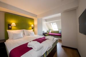 a hotel room with a large bed with towels on it at Three Corners Hotel Art in Budapest +85 photos
