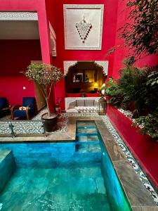 una piscina en medio de una habitación con una pared roja en Riad Hilmuna Hammam et Spa, en Marrakech