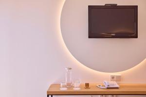 a flat screen tv on a wall with a wooden table at Universal Hotel Bikini in Cala Millor