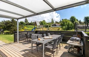a deck with a table and chairs and a grill at Beautiful Home In Ebeltoft With Wifi in Ebeltoft +23 photos