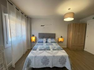 1 dormitorio con 1 cama con manta azul y blanca en Carmen Alta, en Tudela