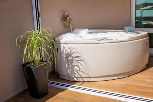 a bath tub sitting next to two potted plants at Casa Colibry in Marinhas