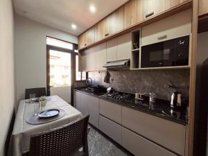 Una pequeña cocina con una mesa y un microondas. en Apartamento Inteligente de Lujo, Comodo y Completo, en Cochabamba