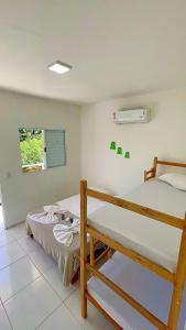 a bedroom with two bunk beds and a window at Pousada Eco Beach in Ubatuba