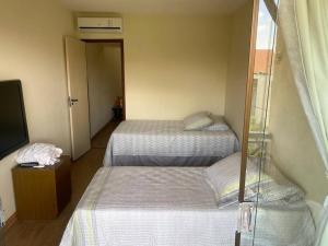 a room with two beds and a tv and a window at Flat para 6 pessoas no Condomínio Monte Castelo Mod 4 Flat 1B in Bezerros +24 photos