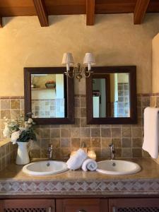 a bathroom with two sinks and two mirrors at Casa Rural El Chorrito in Buenavista del Norte +18 photos