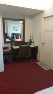 a room with a desk with a mirror and a chair at Nik Adik Khalifa Suites Apartment in Kota Bharu