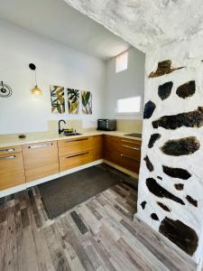 a kitchen with wooden cabinets and a stone wall at Villa Alegría Gran Canaria Piscina Climatizada in Las Palmas de Gran Canaria +42 photos