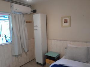 een slaapkamer met een bed en een witte koelkast bij Ríos que nos unen in Colonia del Sacramento