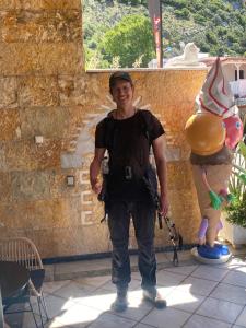 Un homme se tient à côté d'une statue de ballon. dans l'établissement Costas Inn, à Spílion
