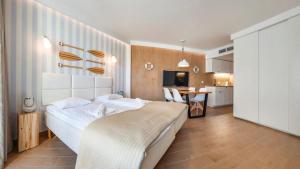 1 dormitorio con 1 cama grande y cocina en Maloves Resort & Spa Prywatne Apartamenty, en Władysławowo