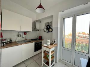 a kitchen with white cabinets and a large window at Casa vacanze da Tonino in Noci