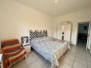 a bedroom with a large bed and a chair at Casa vacanze da Tonino in Noci