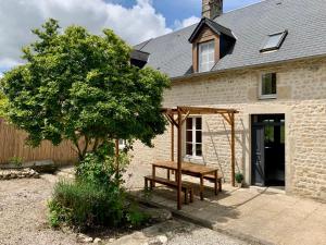 a wooden bench in front of a house at Chambre de Ninon - Le Refuge des Parachutistes - en bordure du marais in Neuville-au-Plain