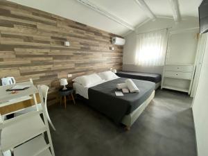 a bedroom with a bed and a wooden wall at Boutique Hotel Nuovo Cason in Cavallino-Treporti